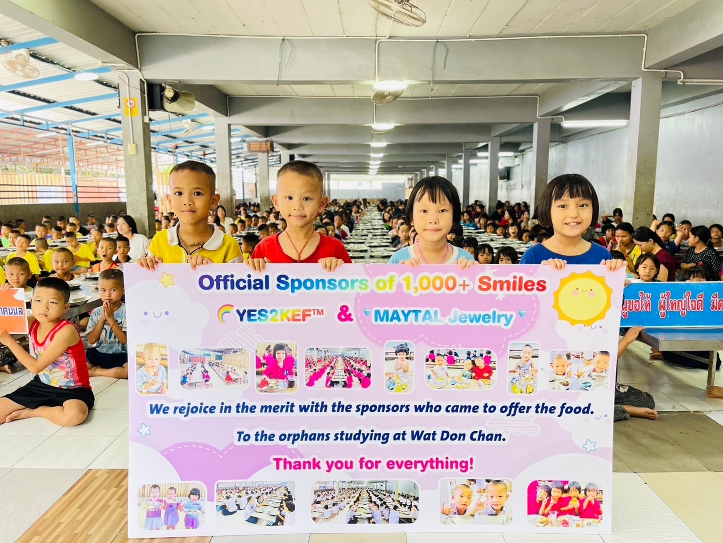 Children holding the YES2KEF™ and MAYTAL Jewelry Official Sponsors of 1,000+ Smiles banner at Wat Don Chan
