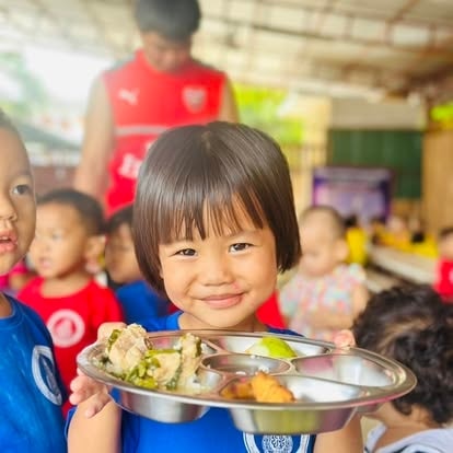 Child sharing a meal during a YES2KEF food-support event